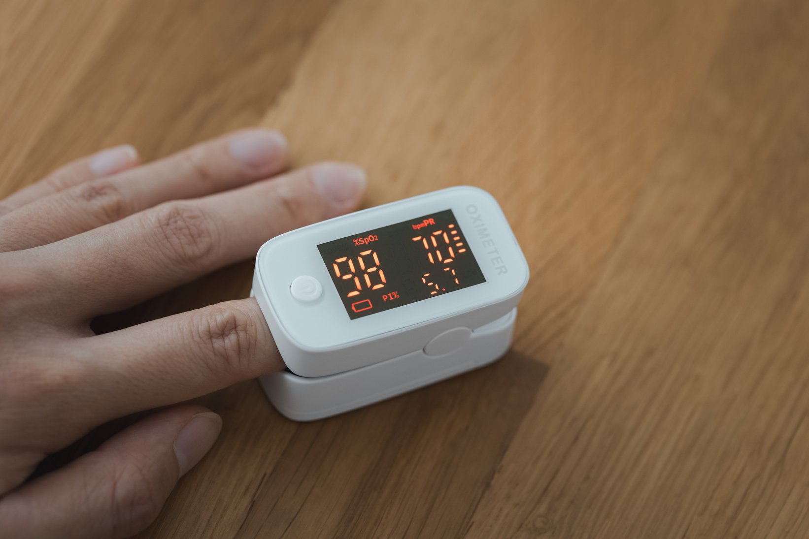 closeup woman hand self monitoring on pulse oximeter